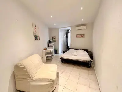 a bedroom with a bed and a couch and a chair at A043-Functional Studio Downtown Cannes in Cannes