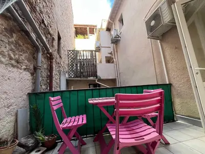 two pink chairs and a table on a balcony at A043-Functional Studio Downtown Cannes in Cannes