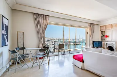 a living room with a couch and a table with chairs at C096-Apt overlooking the Old Port the view is magical in Cannes