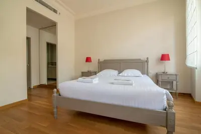 a bedroom with a large white bed with two lamps at C096-Apt overlooking the Old Port the view is magical in Cannes