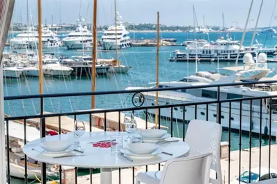 a table on a balcony with a marina with boats at C096-Apt overlooking the Old Port the view is magical in Cannes