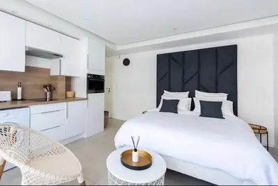 a white bedroom with a large bed and a table at B045-Studio croisette AC close Congress center SEA in Cannes