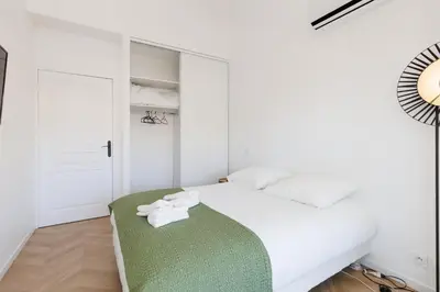 a bedroom with a bed with blue pillows at L'exquis 800m plage et croisette in Cannes