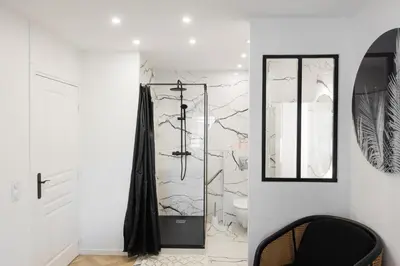 a bathroom with a toilet and a glass shower at L'exquis 800m plage et croisette in Cannes