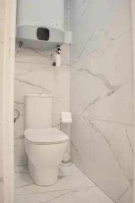 a white toilet in a bathroom with marble walls at STA5 Cannes, le suquet in Cannes