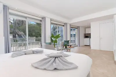 a white bedroom with a large white bed and large windows at Le Louis Blanc - Hypercentre - 100m Suquet - AC in Cannes