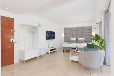 a white bedroom with a bed and a table at Le Louis Blanc - Hypercentre - 100m Suquet - AC in Cannes