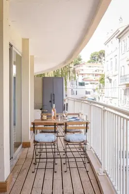 a balcony with a wooden table and two chairs at Le Louis Blanc - Hypercentre - 100m Suquet - AC in Cannes