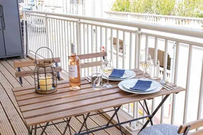 a table with a bottle of wine and glasses on a balcony at Le Louis Blanc - Hypercentre - 100m Suquet - AC in Cannes