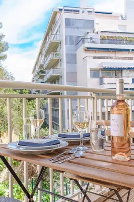 a wooden table with glasses and a bottle of wine at Le Louis Blanc - Hypercentre - 100m Suquet - AC in Cannes