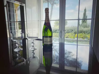 a bottle of wine in a window with two glasses at Villa Lion, gorgeous villa in Le Cannet overlooking Cannes in Le Cannet