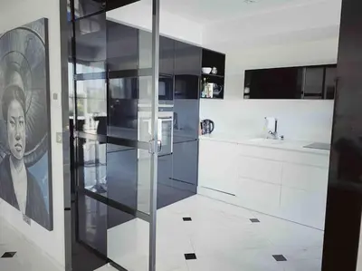 a kitchen with white cabinets and a painting on the wall at Villa Lion, gorgeous villa in Le Cannet overlooking Cannes in Le Cannet