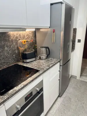 a kitchen with white cabinets and a refrigerator at Chic 47m2, 2 rooms, ground floor, nice patio, 280m beach Croisette in Cannes