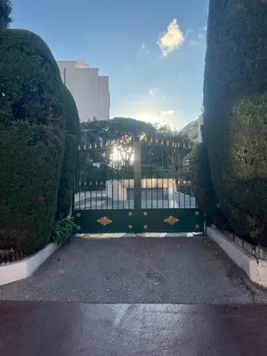 a gate in a garden with a view of a river at Chic 47m2, 2 rooms, ground floor, nice patio, 280m beach Croisette in Cannes