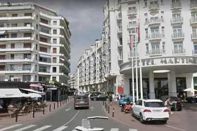 a city street with cars parked in front of buildings at L'Olivier - Croisette Martinez, Studio sur cour, plage 1 min in Cannes