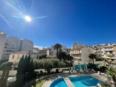 a view of a swimming pool with chairs and buildings at L'Olivier - Croisette Martinez, Studio sur cour, plage 1 min in Cannes