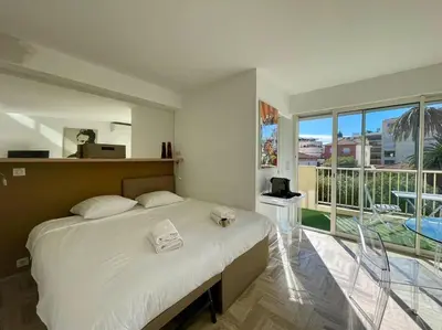 a bedroom with a large bed and a large window at L'Olivier - Croisette Martinez, Studio sur cour, plage 1 min in Cannes