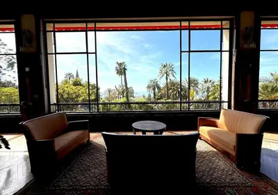 a room with two chairs and a table and a large window at StudioCalifornia-Parking-Plages 15 min walk in Cannes