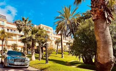 a car parked in front of a building with palm trees at StudioCalifornia-Parking-Plages 15 min walk in Cannes