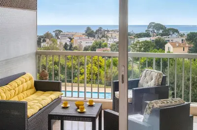 a balcony with a couch and chairs and a view at MIPIM HORIZONS Executive Sea View Apartment 2 Bedrooms Terrace Pool Parking in Cannes