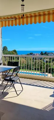 a balcony with a table and a view of the ocean at MIPIM HORIZONS Executive Sea View Apartment 2 Bedrooms Terrace Pool Parking in Cannes