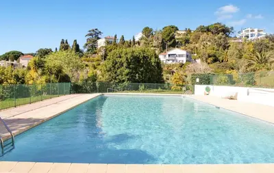 a swimming pool with blue water in a yard at MIPIM HORIZONS Executive Sea View Apartment 2 Bedrooms Terrace Pool Parking in Cannes