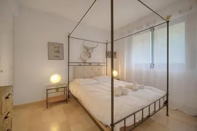 a bedroom with a four poster bed with white sheets at MIPIM HORIZONS Executive Sea View Apartment 2 Bedrooms Terrace Pool Parking in Cannes