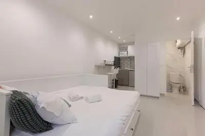 a white room with a large white bed in it at Simon Apartments in Cannes