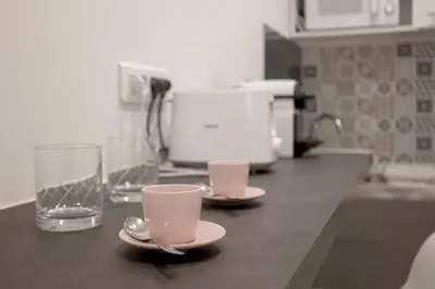 a kitchen counter with two cups and a glass of water at Simon Apartments in Cannes