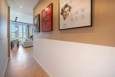 a living room with three framed pictures on a wall at The Palm - 5mn Palais - Croisette - Beaches in Cannes
