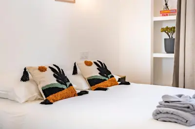 a white bed with two pillows on it at The Palm - 5mn Palais - Croisette - Beaches in Cannes