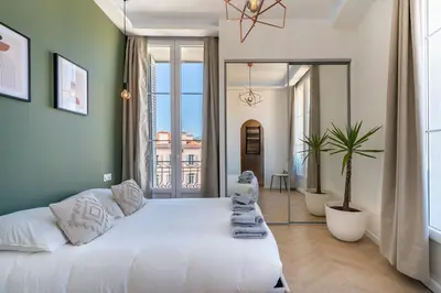 a bedroom with a large white bed and a large window at The Palm - 5mn Palais - Croisette - Beaches in Cannes