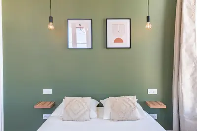 a bedroom with two pictures on the wall and a bed at The Palm - 5mn Palais - Croisette - Beaches in Cannes
