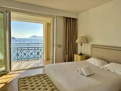 a bedroom with a bed with a view of the ocean at Cannes Croisette - Appartement 5 pièces face mer in Cannes