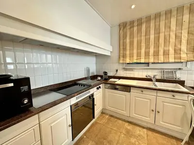 a kitchen with white cabinets and a sink at Cannes Croisette - Appartement 5 pièces face mer in Cannes