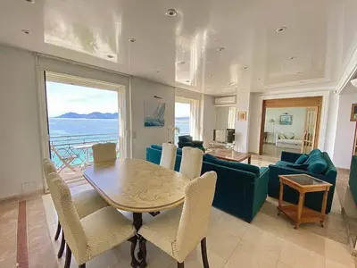 a living room with a table and a couch at Cannes Croisette - Appartement 5 pièces face mer in Cannes