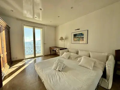 a large white bed in a room with a window at Cannes Croisette - Appartement 5 pièces face mer in Cannes