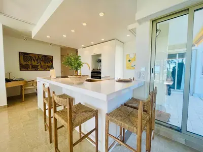 a kitchen with a large white island with chairs at Le Bluebay - Luxurious 2 bedrooms seaview swimming pool carpark in Cannes