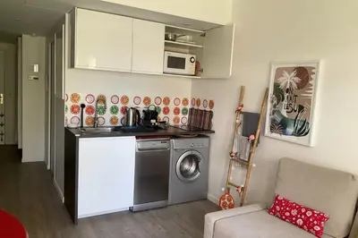 a kitchen with a washing machine and a microwave at Charming refurbished cocoon with swimming pool in Cannes