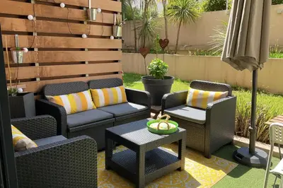 a patio with wicker chairs and a table at Charming refurbished cocoon with swimming pool in Cannes