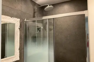 a shower with a glass door and a mirror at Charming refurbished cocoon with swimming pool in Cannes
