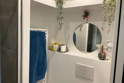a bathroom with a mirror and a blue towel at Charming refurbished cocoon with swimming pool in Cannes