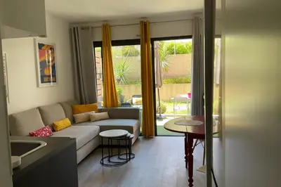 a living room with a couch and a table at Charming refurbished cocoon with swimming pool in Cannes
