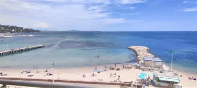 a group of people on a beach near a pier at AMAZING SEA VIEW APARTMENT in Cannes