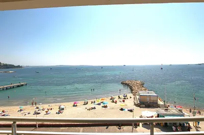 a beach with a bunch of people in the water at AMAZING SEA VIEW APARTMENT in Cannes