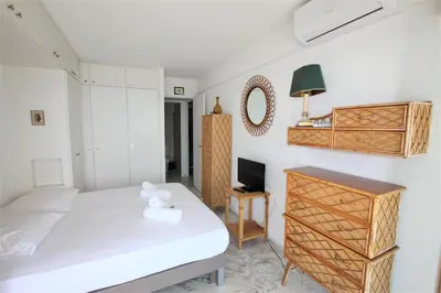 a bedroom with a bed and a desk and a tv at AMAZING SEA VIEW APARTMENT in Cannes