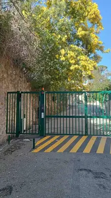 a black gate with yellow stripes on the side of it at 3 Pièces avec grand Jardin in Cannes