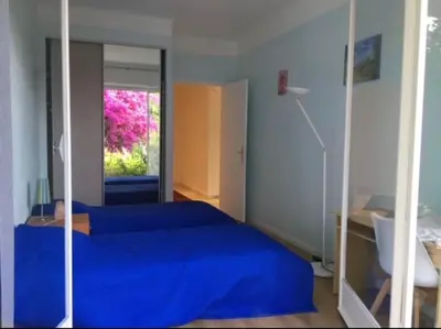 a bedroom with a blue bed and a mirror at 3 Pièces avec grand Jardin in Cannes