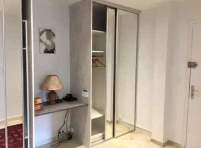 a room with a closet with a table and a lamp at 3 Pièces avec grand Jardin in Cannes