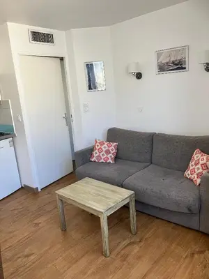 a living room with a couch and a coffee table at 2 pièces avec piscine, 150 m de la plage. in Cannes
